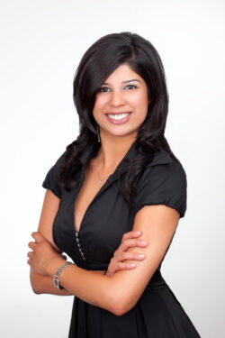 Professional business portrait of a smiling woman with crossed arms on a clean white background, captured by Exposures Photography in Toronto.